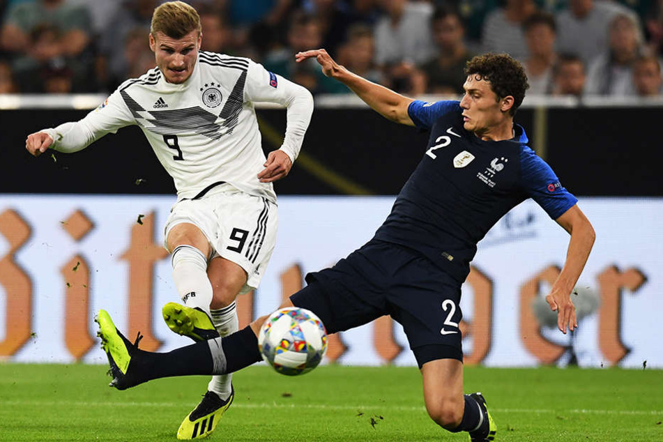 Deutschlands Timo Werner (l.) scheitert mit seinem unplatzierten Schuss an Frankreichs Schlussmann Alphonse Areola. Benjamin Pavards (r.) eingesprungene Grätsche kommt zu spät.