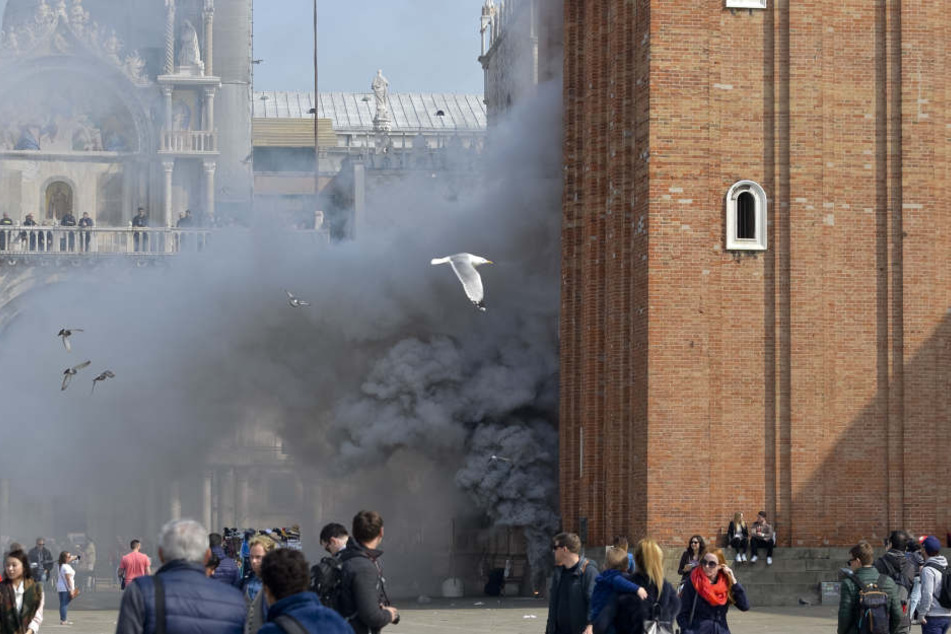 Rauch quillt am 17.03.2017 an der Fassade eines Gebäudes am Markus-Platz in Venedig
(Italien). Nach Medienberichten wollten Räuber mit Rauchbomben Panik
unter den Touristen verbreiten und dann einen Juwelier überfallen.