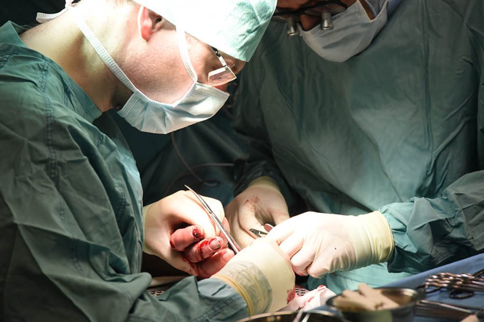 In der Plastischen Chirurgie im Magdeburger Universitätsklinikum operieren Oberarztarzt Armin Kraus (l.) und Assistenzarzt Felix Hövelborn ein Opfer von Böllern und Raketen an der Hand. Etliche Menschen sind dort nach Unfällen behandelt worden.