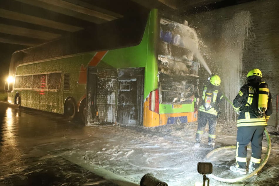 Feuerwehrmänner löschen den Brand am Flixbus.