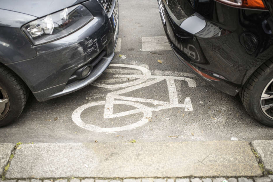 Geparkte Autos stehen auf einem Radweg.