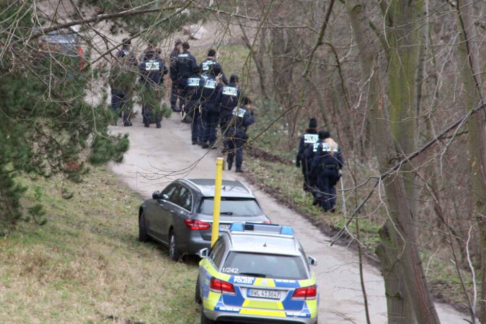 Polizisten suchen am 12.01.2018 bei Mannheim in einem Waldstück am Pfingstbergweiher in der Nähe der Fundstelle einer Leiche eines Neugeborenen nach Spuren.