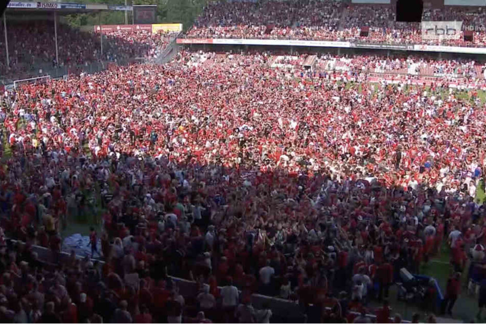 Nach Abpfiff stürmten die Fans den Platz und mittendrin das Fernsehteam des RBBs.