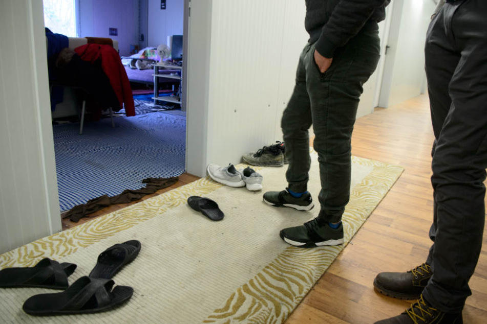 Geflüchtete Syrer stehen am Eingang ihrer Unterbringung.