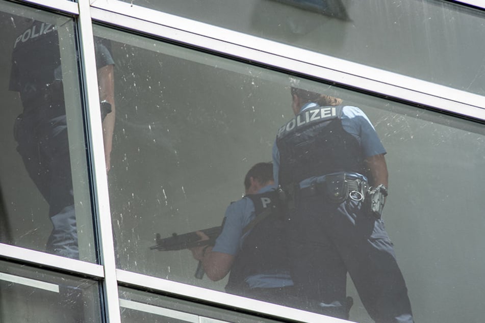 Schwer bewaffnete Polizisten nähern sich der nächsten Parkebene um diese abzusuchen.