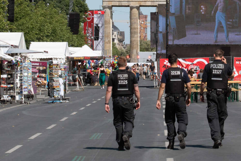 Polizisten gehen über die gesperrte Straße des 17. Juni, während nur wenige Fans die Übertragung des Achtelfinalspiels bei der Fußball-Weltmeisterschaft zwischen Schweden und der Schweiz verfolgen.