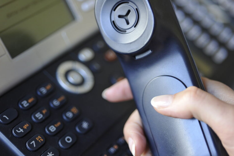 Eine Frau hält einen Telefonhörer in der Hand (Symbolbild).