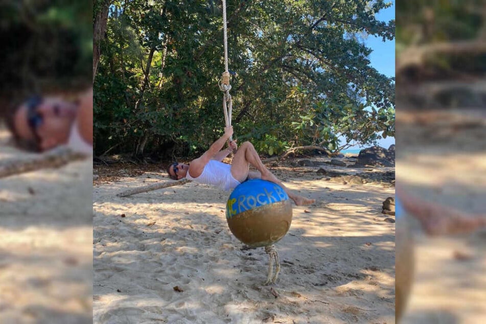 Musiker Sasha schwingt auf einer Kugel am thailändischen Strand.