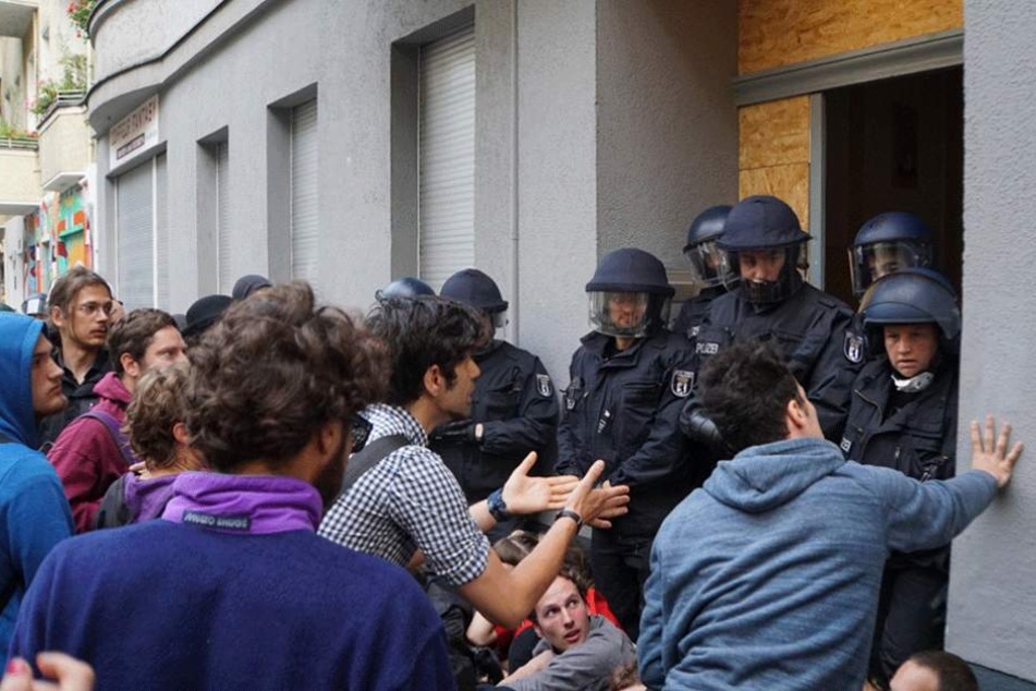 Demonstranten reden vor dem Friedel 54 auf die Polizisten ein.
