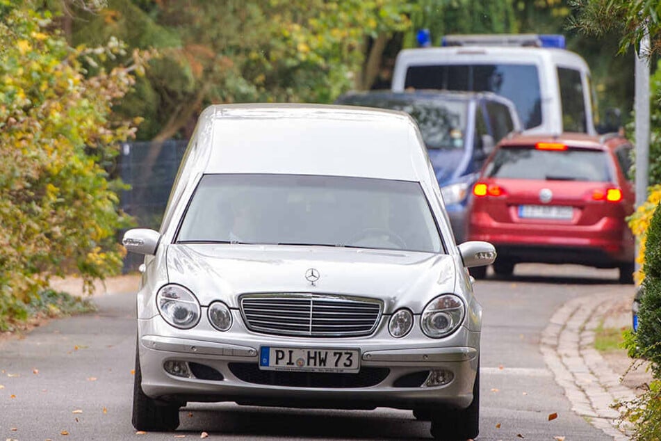 Die tote Frau wird mit dem Leichenwagen vom Grundstück transportiert.