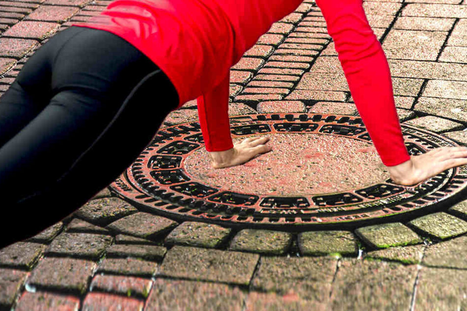Als der Mann die Straße entlang lief, überkam es ihn plötzlich. Ganz ungeniert vergnügte er sich mit einem Gullideckel.