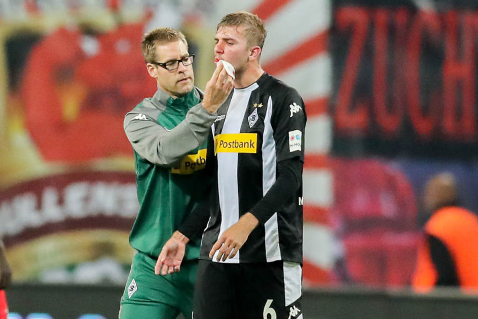 Sichtlich mitgenommen wird Christoph Kramer von einem Teamarzt versorgt. Keita hatte den Gladbacher mit seinen Stollen im Gesicht getroffen.