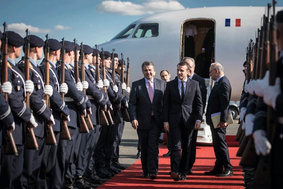 Sigmar Gabriel (l, SPD), Vizekanzler und Bundesaussenminister, begrüsst den neuen Präsidenten von Frankreich Emmanuel Macron am Flughafen Tegel in Berlin.