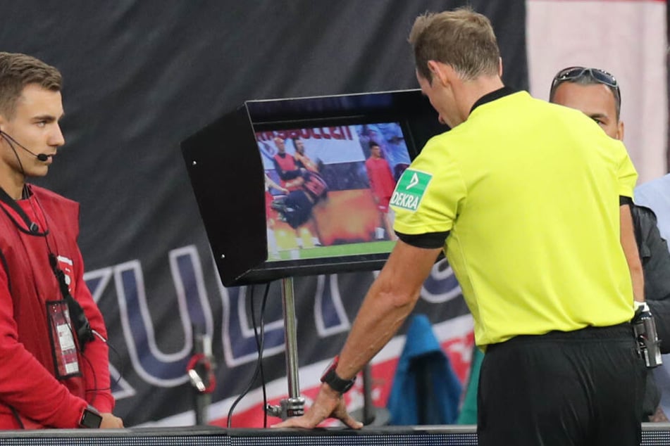 4. Spieltag: Schiedsrichter Sascha Stegemann (r) schaut sich eine Spielszene zwischen RB Lepzig und dem FC Bayern München mit Videobeweis auf einem Monitor an.
