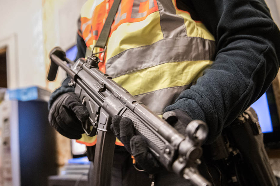 Ein Berliner Polizei mit seiner Dienstwaffe im Anschlag. (Symbolbild)