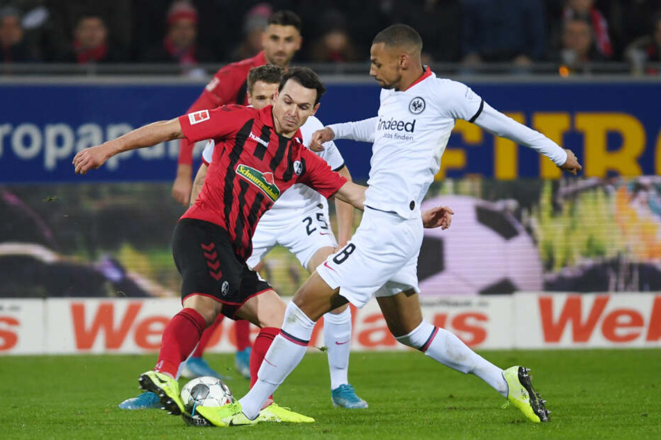 Nicolas Höfler (Li.) vom SC Freiburg und Eintrachts Djibril Sow kämpfen um den Ball.