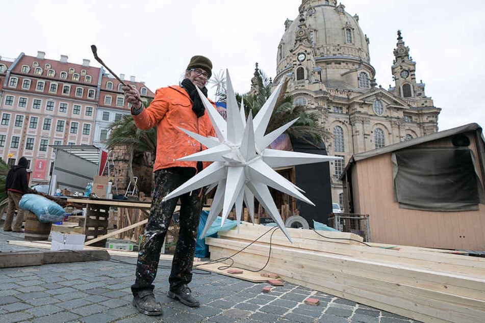 Maler Charles Wiegmann (64) bringt am Neumarkt einen Weihnachtsstern an. Der "Advent auf dem Neumarkt" öffnet am Donnerstag.
