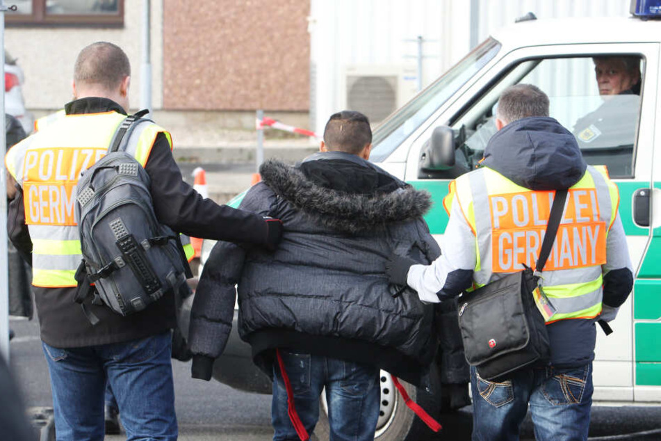 Polizisten begleiten einen straffällig gewordenen Asylbewerber zum Flughafen.