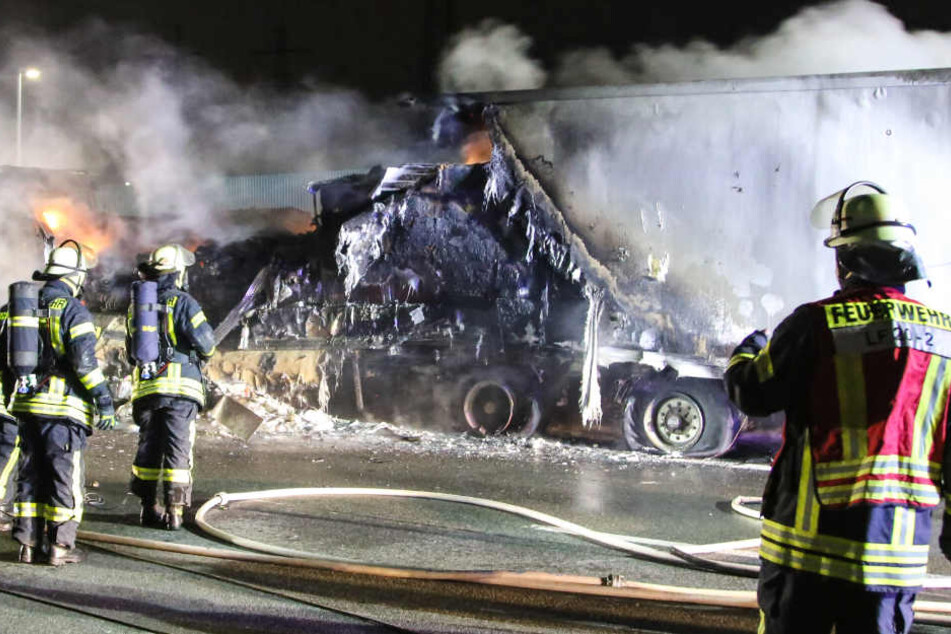 Feuerwehrleute löschen den brennenden Lastwagen.