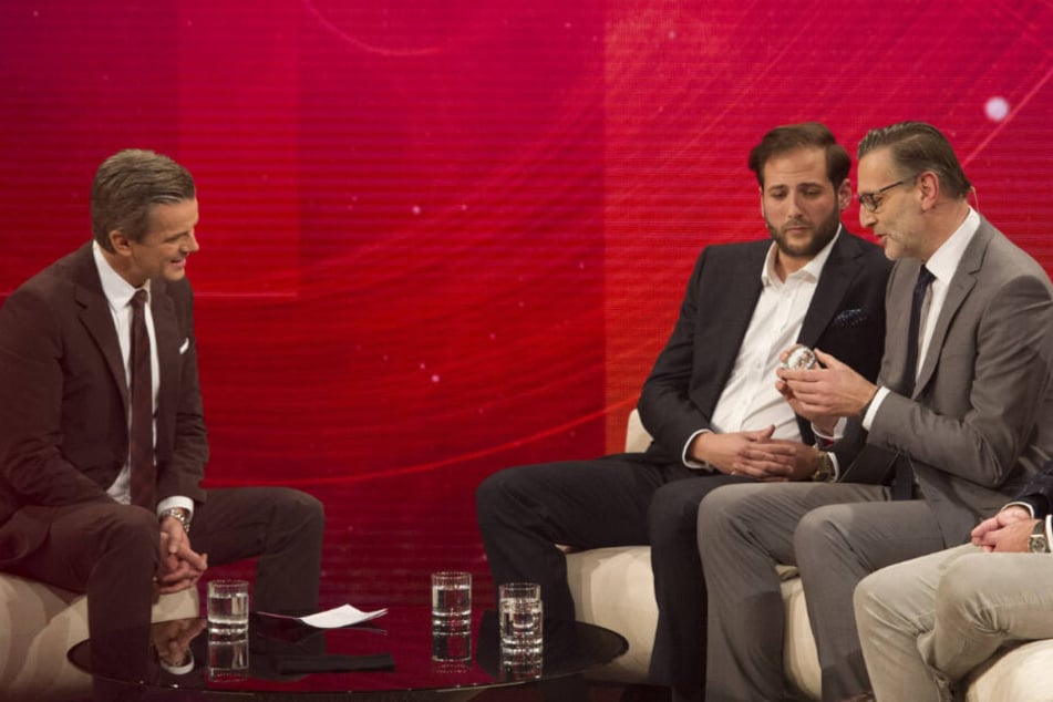 Markus Lanz (links) sitzt mit den Trödlern Detlev Kümmel (rechts) und Julian Schmitz-Avila an einem Tisch. (Archivbild)