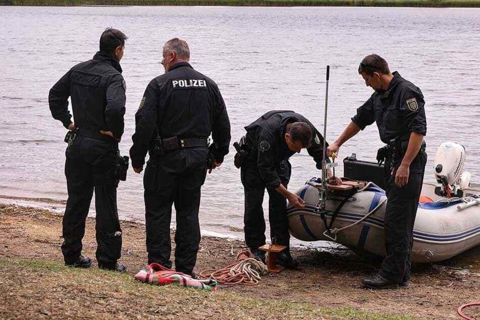 Einsatzkräfte der Polizei am Ufer des Dippelsdorfer Sees. Taucher fanden die Leiche des Mannes an der Oberfläche treibend.