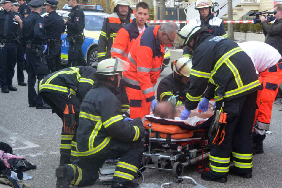Feuerwehrleute und Sanitäter versorgen den verletzten Mann in der Nähe des Einkaufszentrums Quarree.