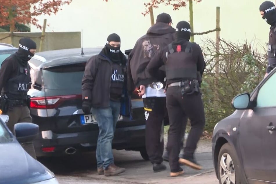 SEK-Kräfte führen den Mann in Handschellen ab.