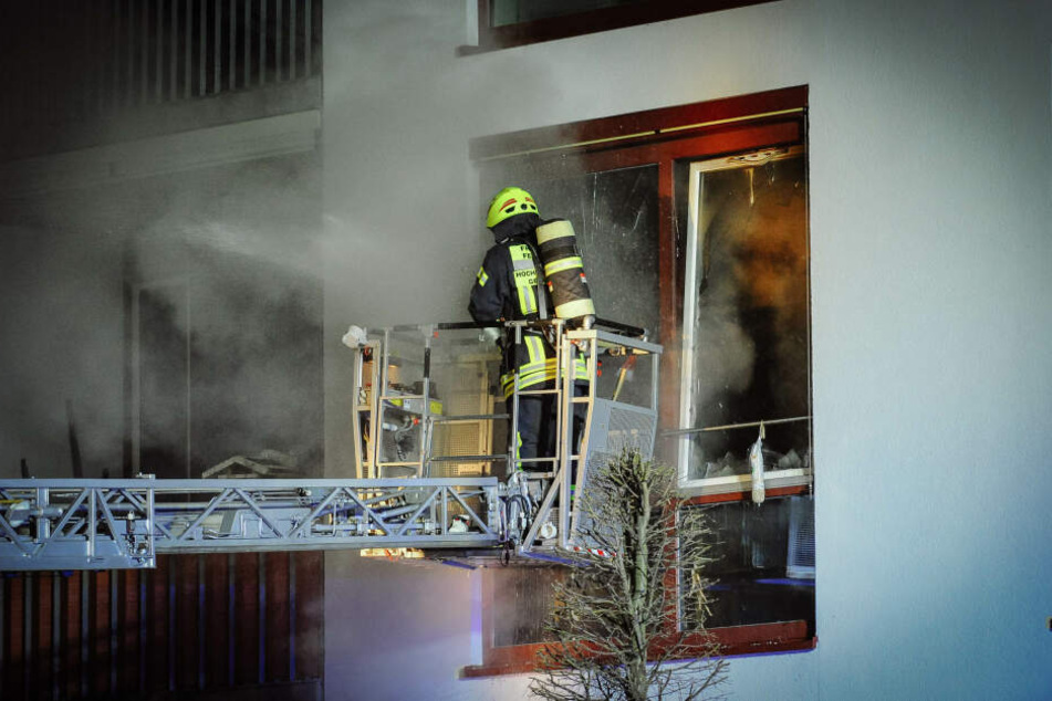 Ein Feuerwehrmann kämpft auf einer Drehleiter gegen die Flammen.