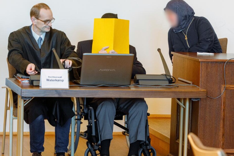 Der Angeklagte sitzt zwischen seinem Anwalt Stefan Waterkamp (l) und seiner Begleiterin im Gerichtssaal.