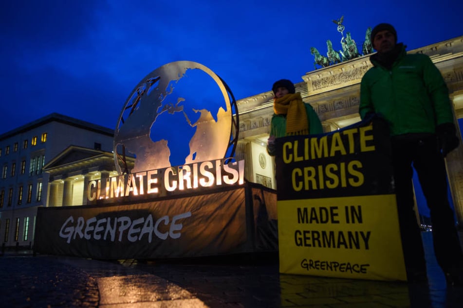 Greenpeace-Aktivisten haben am Dienstagmorgen mit einer brennenden Weltkugel vor dem Brandenburger Tor protestiert.
