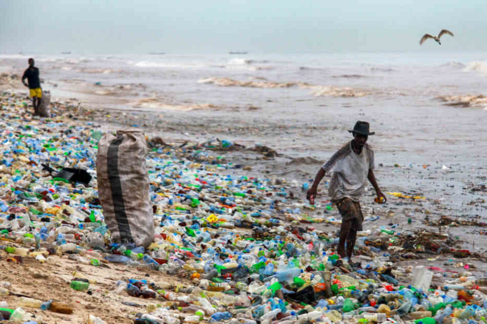 Ein Mann läuft durch den völlig verschmutzten Kohle Gono Strand in Ghana.