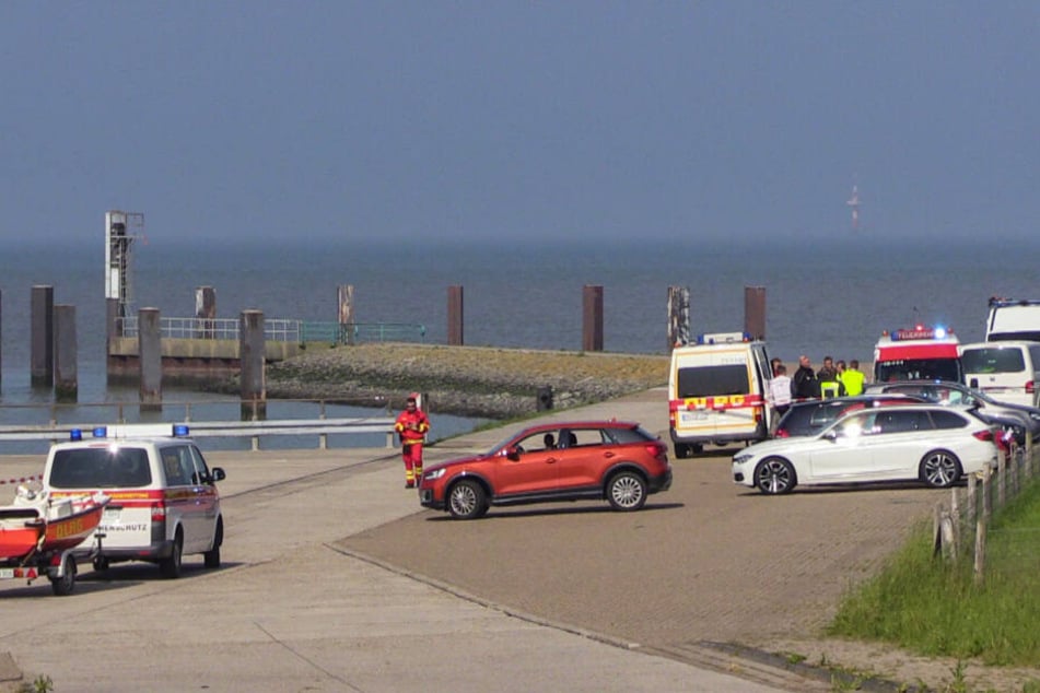 Helfer der Deutschen Lebens-Rettungs-Gesellschaft stehen bei einer Suchaktion auf einem Parkplatz neben der Nordsee.
