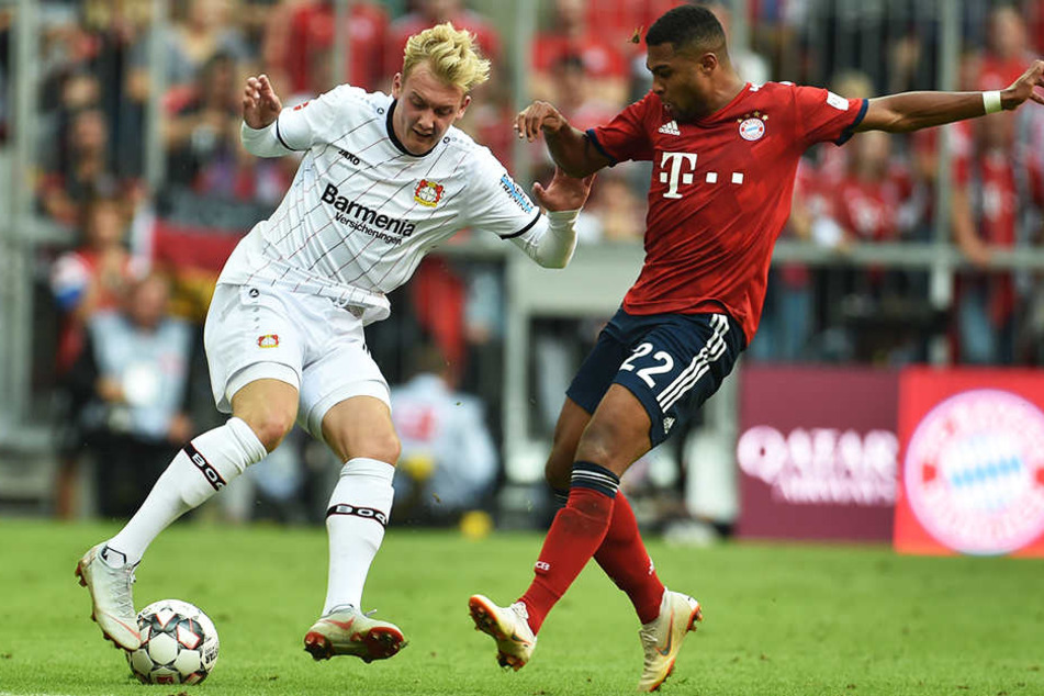 Leverkusens Julian Brandt (l.) im Duell mit Bayerns Serge Gnabry (r.).