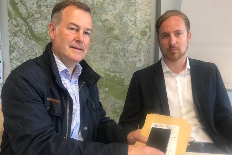 Henning Stiegmann vom Staatsschutz Bielefeld (l.) und Staatsanwalt Christoph Hebbecker präsentieren das sichergestellte Smartphone.