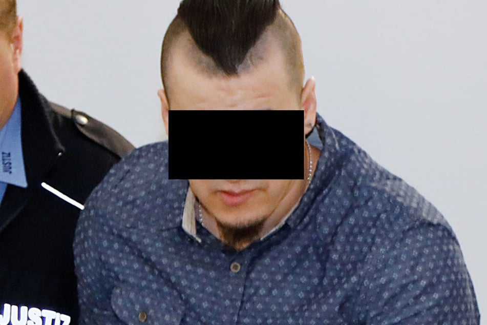 Der Angeklagte wird in den Gerichtssaal gebracht.