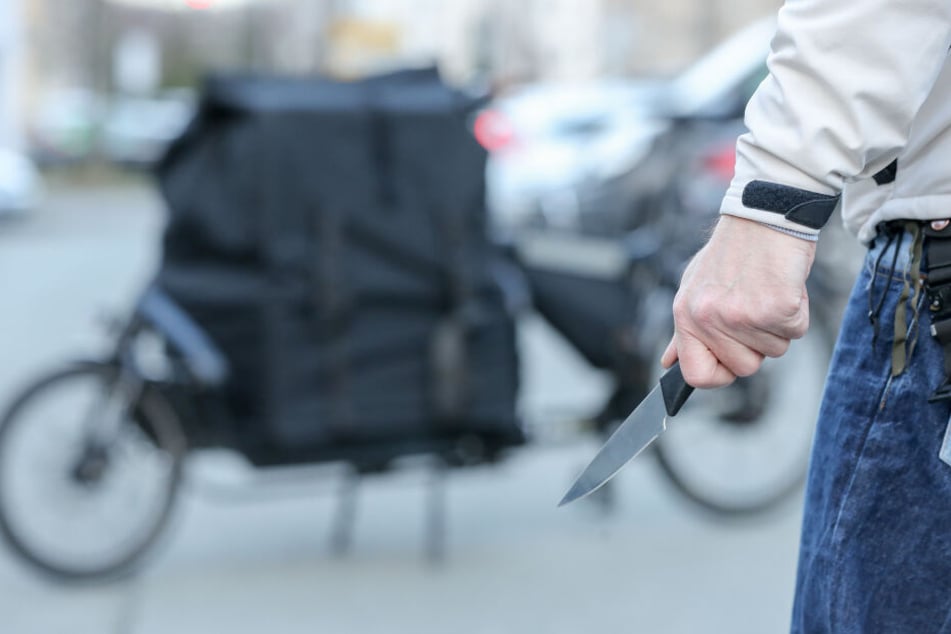 Ein Mann steht mit einem Messer in der Hand (Symbolbild).