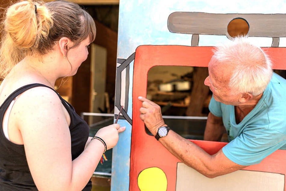 Zwei Bufdis aus zwei Generationen bei der Arbeit: Julia Bartsch (17) und Klaus Schnabel (68) an einer Fotowand.