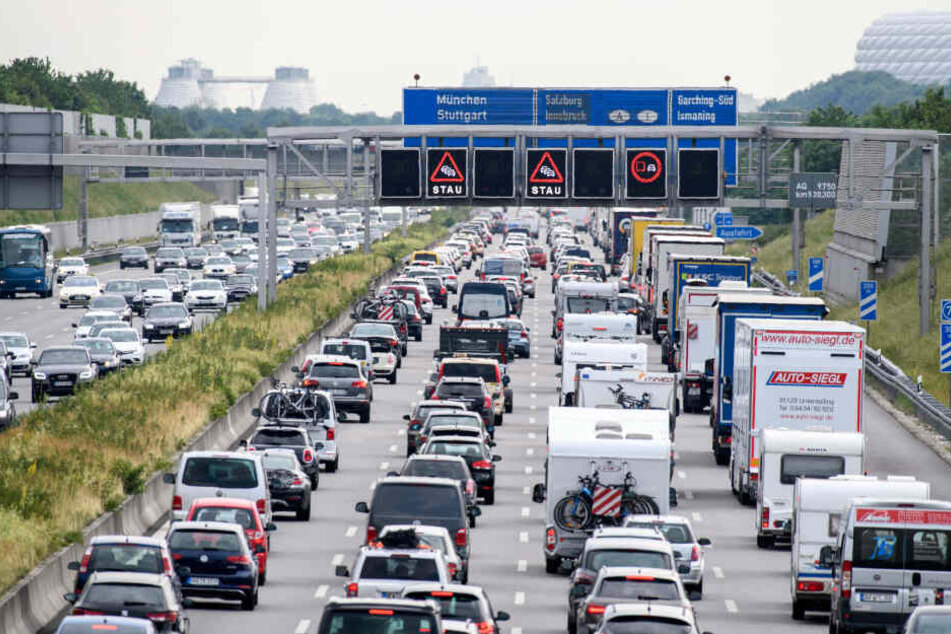 Zähfließender Verkehr herrscht auf der Autobahn A9 bei München, während auf einer Anzeigetafel über der Autobahn vor Stau gewarnt wird.
