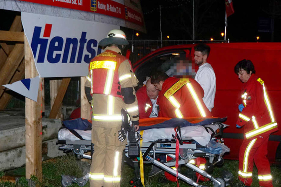 Die Rettungskräfte holen den verletzten Mann aus dem Wagen.