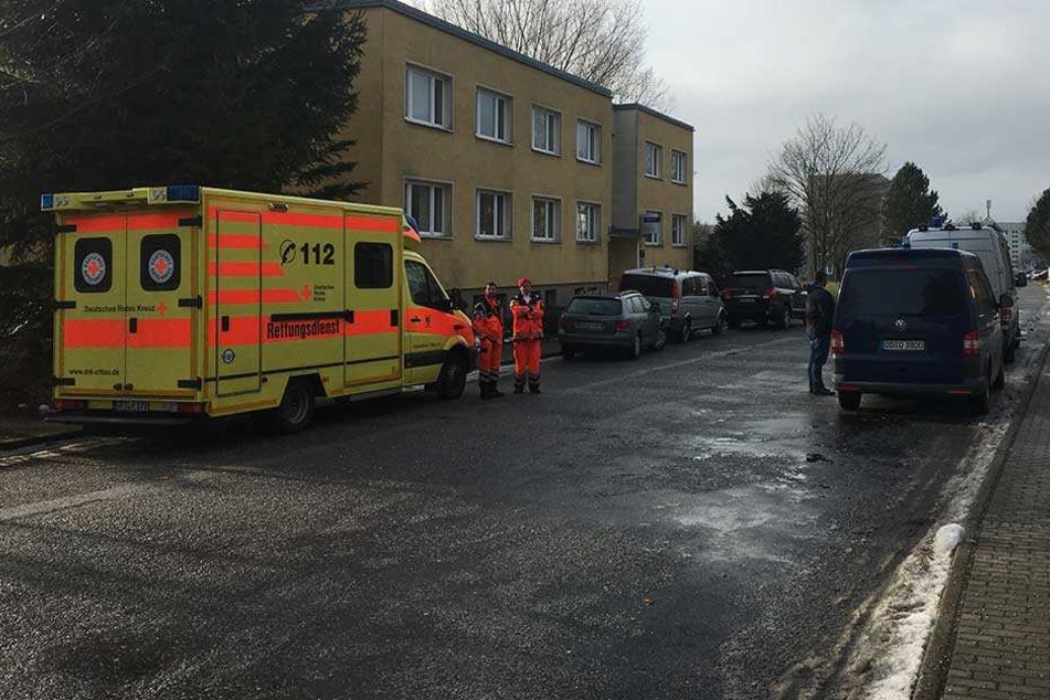 Polizei und Rettungskräfte stehen in Neugersdorf vor dem Plattenbau.