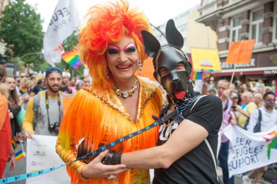 Dragqueen Olivia Jones posiert bei der CSD-Parade 2017 mit einem maskierten Fan.