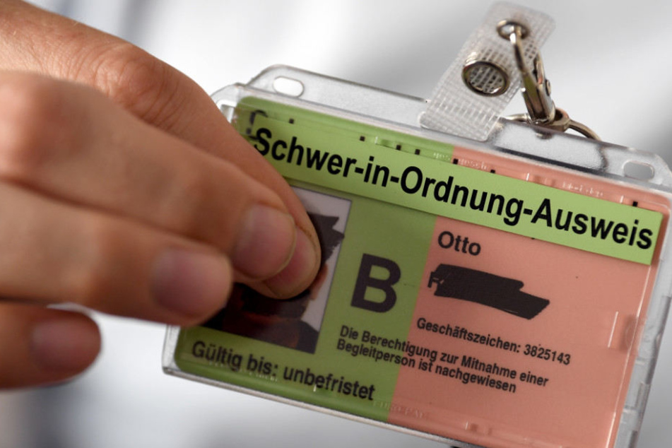 in junger Mann zeigt seine neue Hülle für seinen Schwerbehindertenausweis.