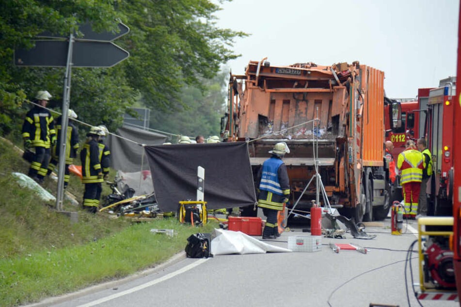 Feuerwehrkräfte arbeiten auf einer Straße bei Nagold an einer Unfallstelle, an der ein Müllwagen auf ein Auto gekippt war. Nach ersten Angaben der Polizei sind bei dem Unfall fünf Menschen ums Leben gekommen. (Archivbild)