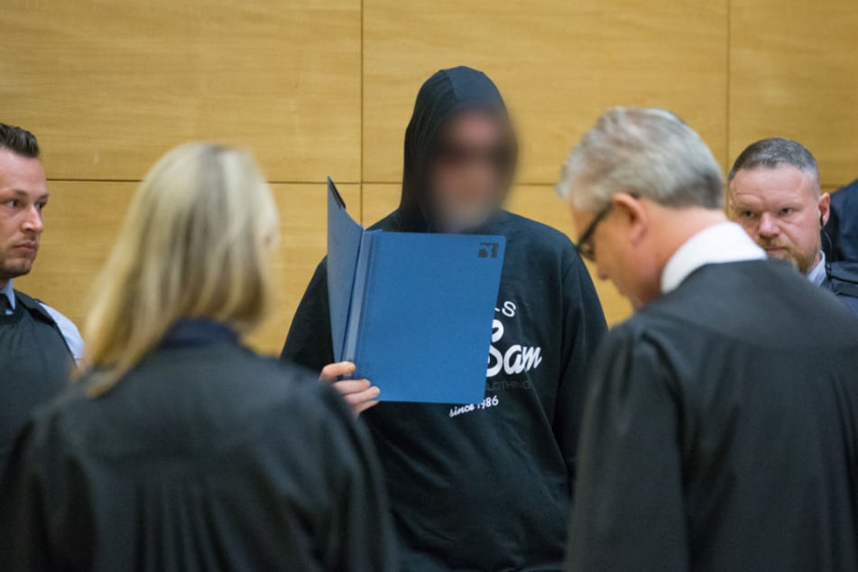 Vor Gericht erschien der Mörder mit einem Aktenordner vorm Gesicht.