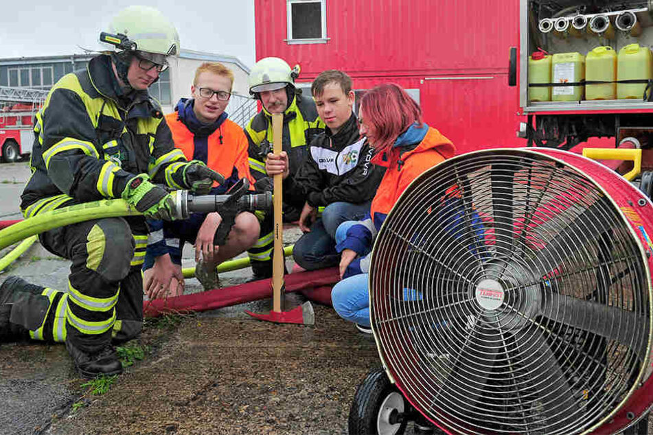 Feuerwehrmann Julian Schubert (18, l.) erklärt die Funktion der Spritzdüse am Feuerwehrschlauch.
