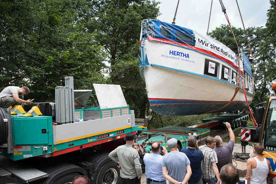 Zwei Kräne verladen das am Ufer des Klempowsees auf Dock liegende Schiff "Hertha".