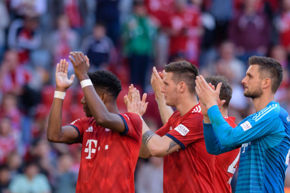 David Alaba (l-r), Niklas Süle und Sven Ulreich vom FC Bayern München feiern ihren Sieg gegen Bremen mit den Fans.