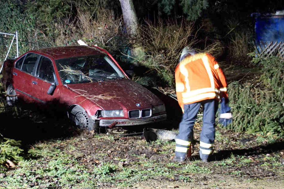 Ein Feuerwehrmann am Wrack des BMW.