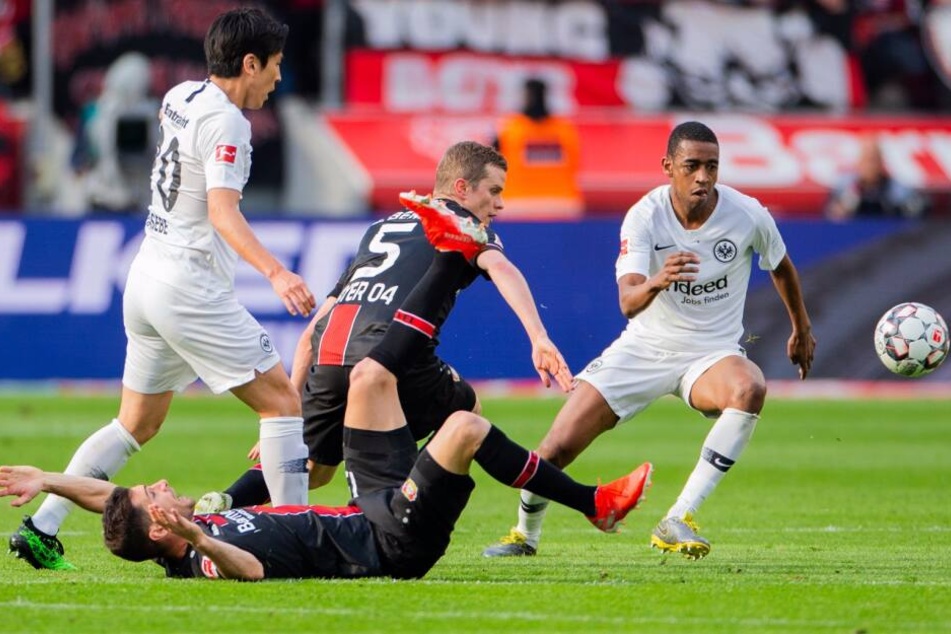 Lucas Alario (liegend) wird von Makoto Hasebe (li.) zu Fall gebracht.