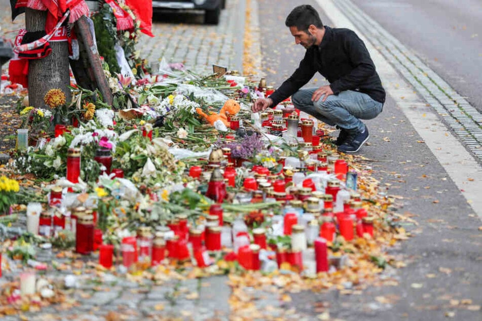 Izzet Cagac legt vor seinem Imbiss Blumen im Gedenken an die Todesopfer ab.